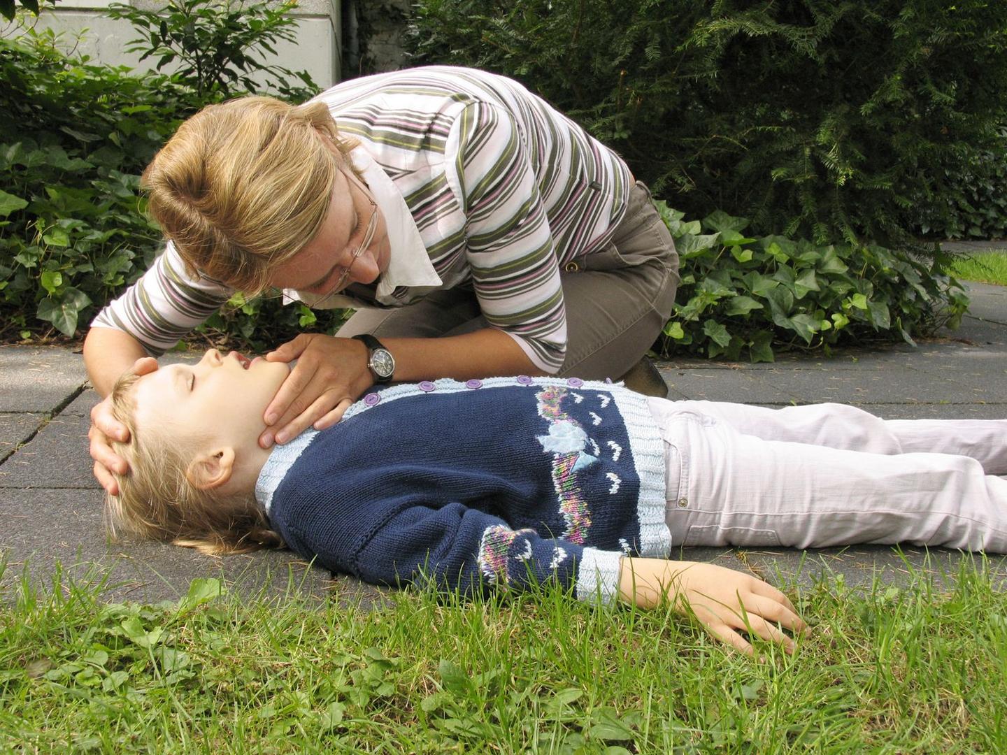 Eine Mutter hilft ihrem gestürzten Kind